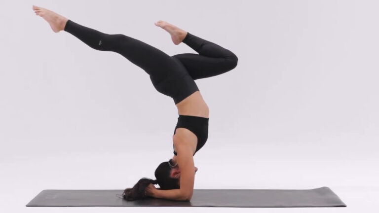 Person performing a Forearm Stand (Pincha Mayurasana) with legs gracefully extended, balancing on forearms