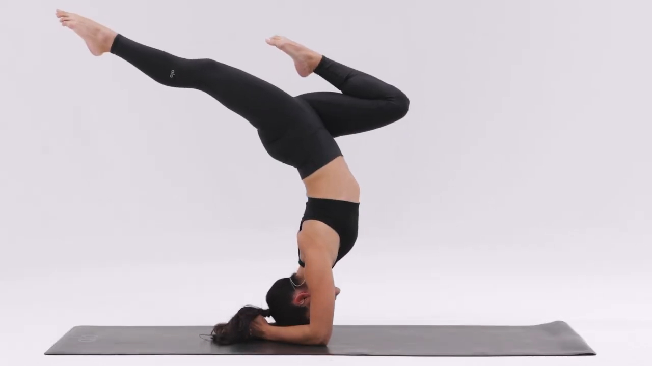Person performing a Forearm Stand (Pincha Mayurasana) with legs gracefully extended, balancing on forearms
