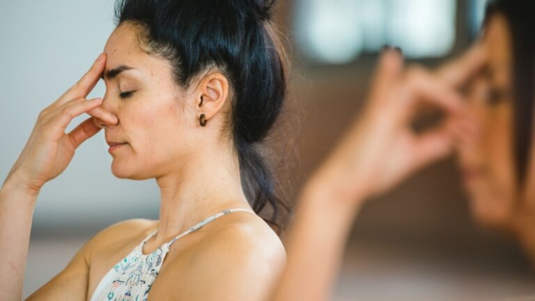 Woman practicing alternate nostril breathing, a common technique in pranayama for anxiety