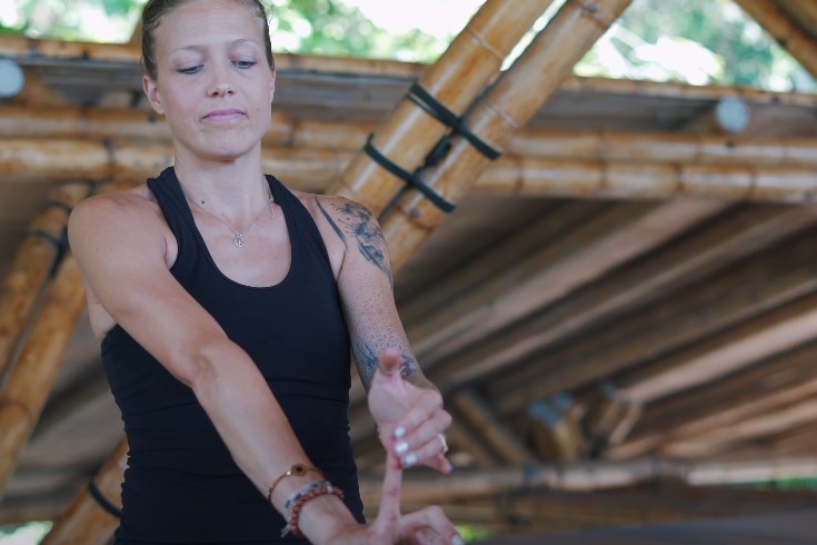 Woman stretching her wrist and fingers after yoga session